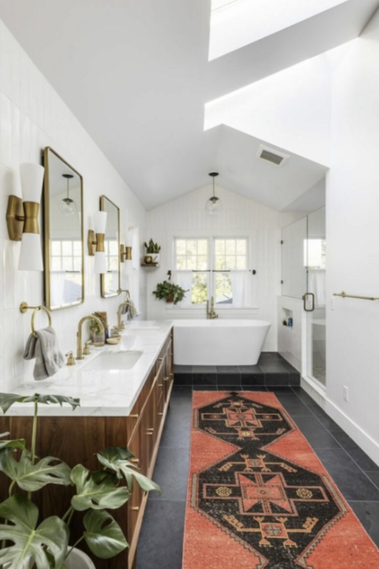 Master bathroom with vaulted ceiling, skylight, and freestanding tub